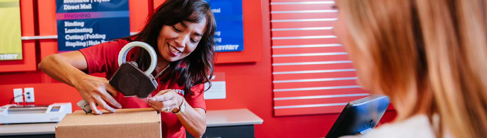 PostNet Employee Taping a Package