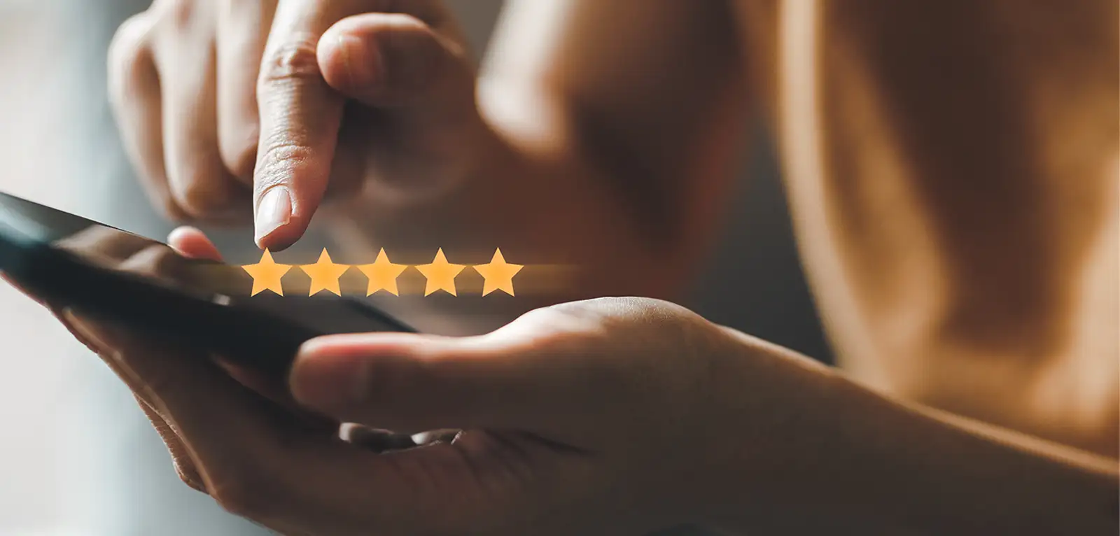 Close-up on someone reviewing a company with their phone and leaving 5 stars.