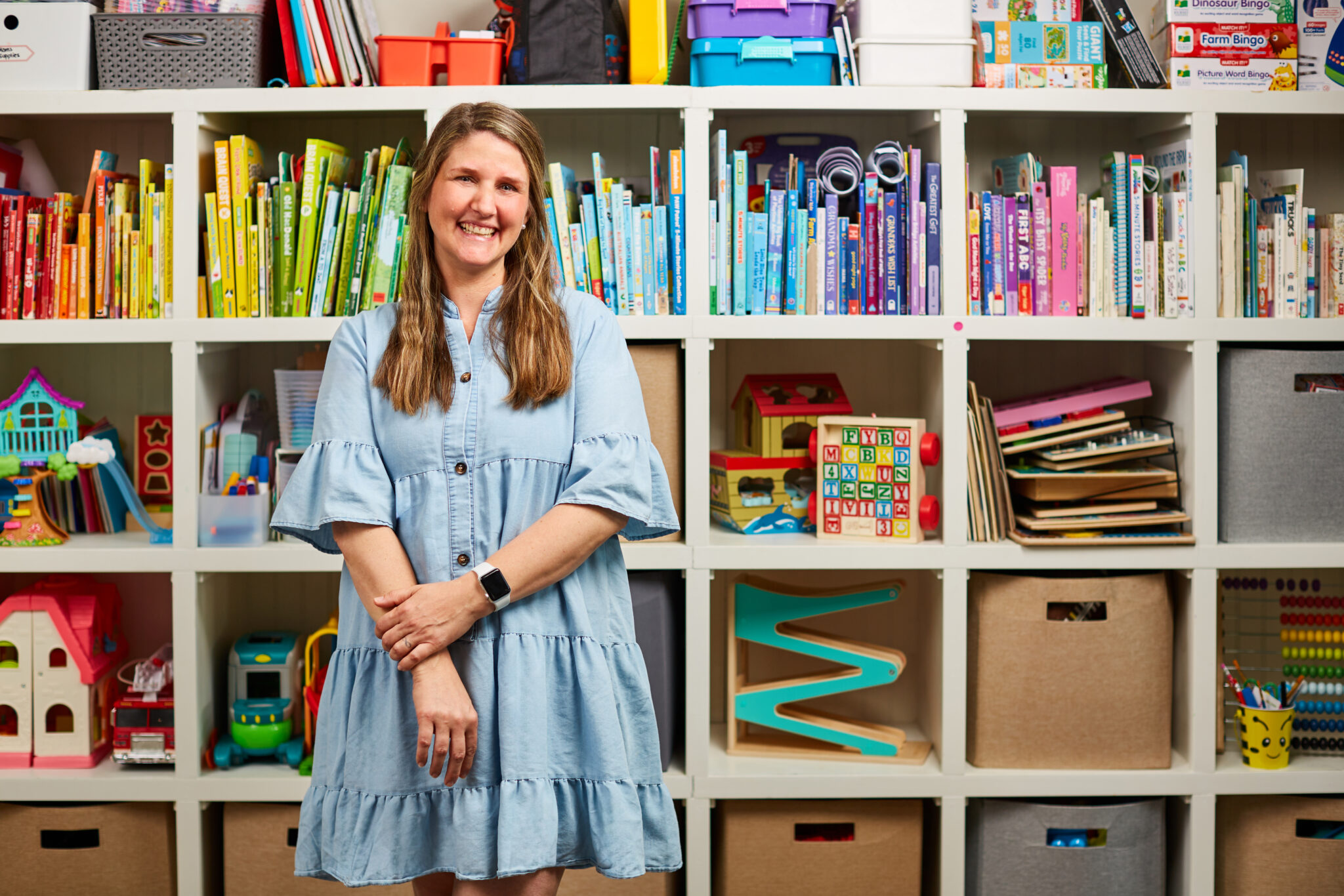 Teacher standing in front of bookshelf