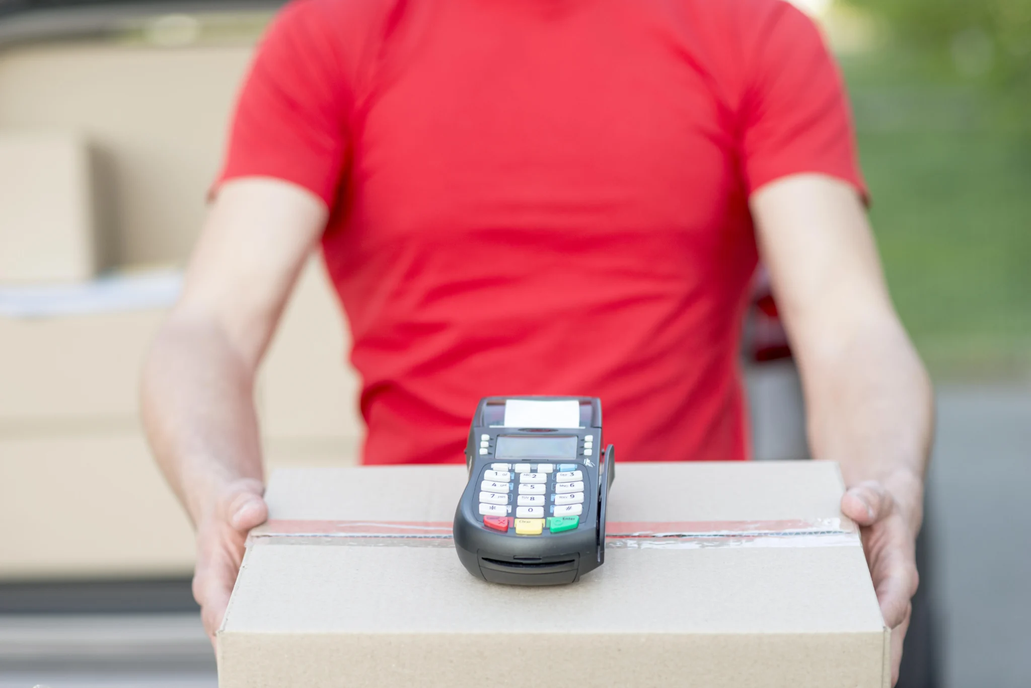 close up of a guy holding a POS machine to take payment for a shipment